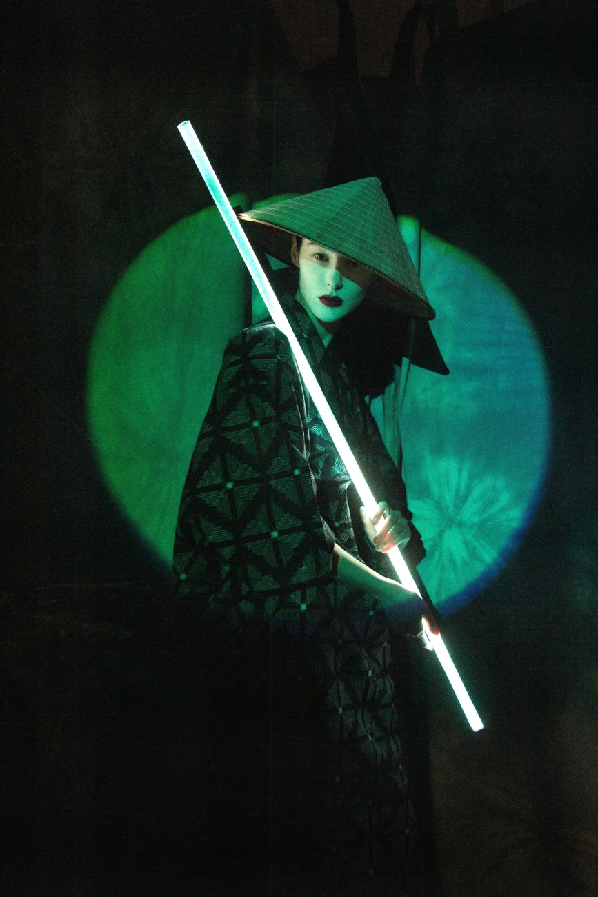 an asian actress holding a light stick and looking at camera